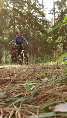 Pareja-De-Ciclismo-De-Montaña-Montando-En-El-Bosque-En-Un-Día-Soleado