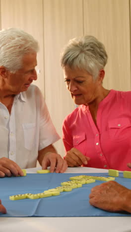 Senior-friends-talking-while-playing-dominos