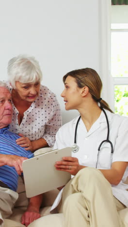 Nurse-doing-a-health-check-up-with-mature-man-on-a-sofa