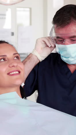 Dentista-Sonriente-Examinando-A-Un-Paciente