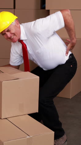 Warehouse-manager-injuring-his-back-moving-boxes