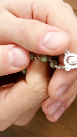 Praying-hands-holding-rosary