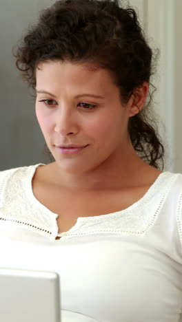 Pregnant-woman-relaxing-on-the-couch-using-laptop