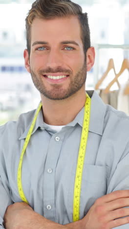 Handsome-fashion-designer-smiling-at-camera-with-arms-crossed