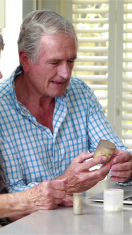 Senior-couple-using-laptop-and-holding-pills