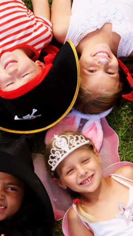 Group-of-kids-in-various-costumes-lying-on-grass