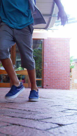 Smiling-school-kids-running-in-corridor-at-school