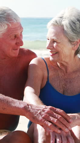 Retired-old-couple-sitting-on-towel