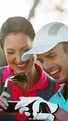 Two-happy-golfers-taking-a-selfie-in-golf-buggy