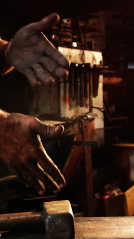 Mid-section-of-blacksmith-rubbing-his-hands