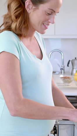 Pregnant-woman-preparing-vegetables-in-kitchen