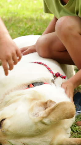 Brother-and-sister-rubbing-their-dog