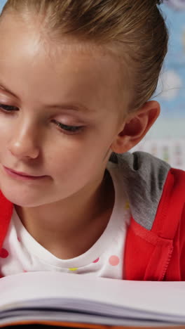 Schoolgirl-doing-homework-in-classroom-at-school