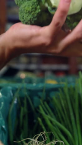 Smiling-male-staff-assisting-a-woman-with-grocery-shopping