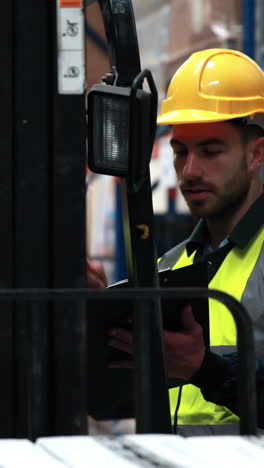 Warehouse-worker-talking-with-forklift-driver-