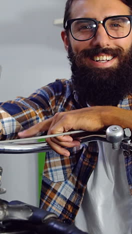 Portrait-of-mechanic-with-bicycle-in-workshop