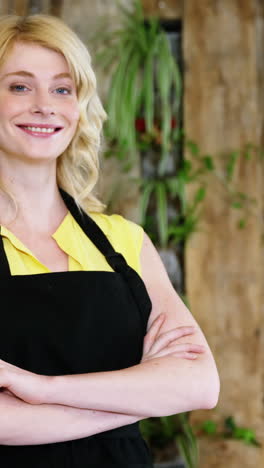 Portrait-of-waitress-standing-with-arms-crossed-at-counter