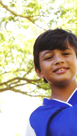 Niño-Sonriente-Jugando-Al-Fútbol-En-El-Parque