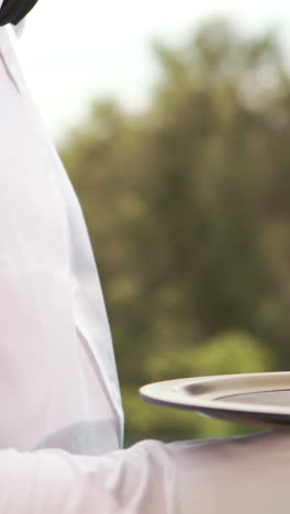 Smiling-waiter-holding-champagne-glasses