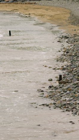 Ozean-Kommt-über-Kiesstrand-Herein