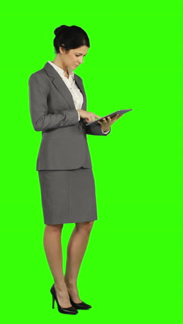 Business-woman-standing-and-using-a-tablet