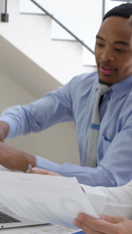 Close-on-two-businessmen-smiling-and-working-with-a-laptop