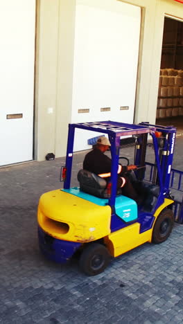 Warehouse-worker-driving-forklift