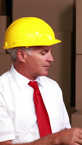 Warehouse-manager-sitting-using-his-tablet-pc