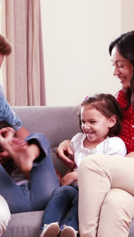 Familia-Feliz-Haciendo-Cosquillas-En-El-Sofá