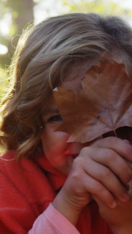 Girl-hiding-smile-behind-leaf