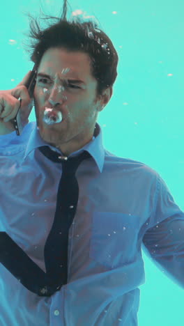 Businessman-underwater-talking-on-smartphone