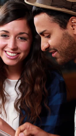 Smiling-couple-looking-at-tablet-