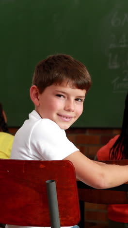 Little-boy-turning-to-smile-at-camera-during-class