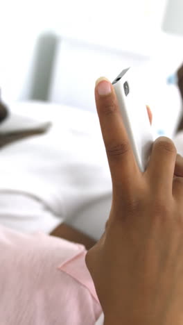 Happy-couple-using-mobile-phone-on-bed