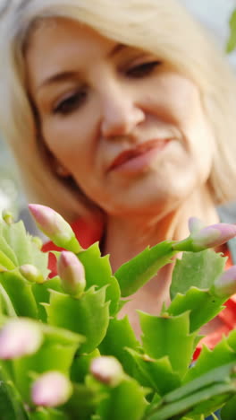 Mature-woman-checking-pot-plant