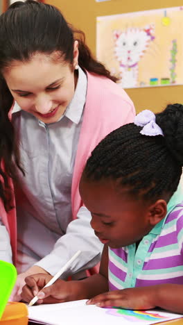 Teacher-and-pupils-working-at-desk-together