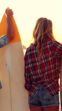 Happy-friends-holding-surfboards