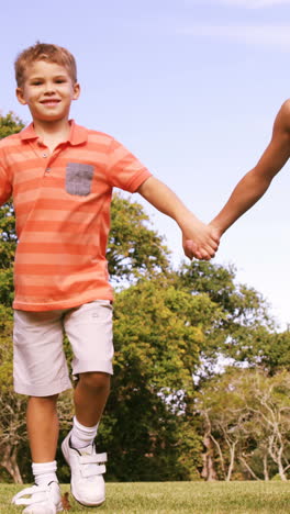 Group-of-children-walking-hand-in-hand-in-park