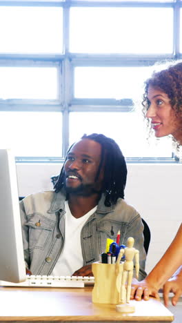 Colleagues-looking-at-computer-and-discussing-with-each-other