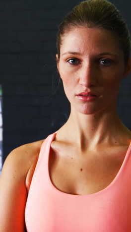 Portrait-of-woman-in-sportswear-standing-in-gym