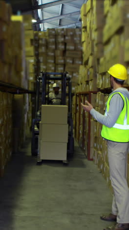 Trabajador-De-Almacén-Dirigiendo-Al-Conductor-Del-Montacargas