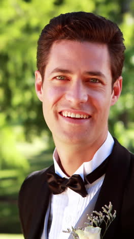 Attractive-groom-walking-towards-and-smiling-at-camera-