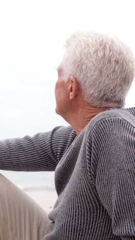 Thoughtful-retired-man-sitting-on-the-beach