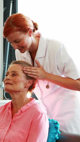 Nurse-doing-facial-massage-to-her-senior-patient