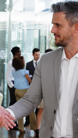 Business-people-shaking-hands-in-office