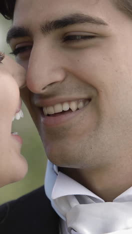 Groom-posing-with-his-pretty-new-wife-in-a-park