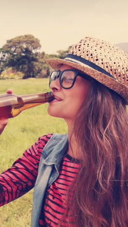 Happy-hipster-drinking-beer-in-the-park