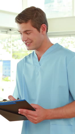 Two-doctors-working-with-clipboard-and-looking-at-camera-