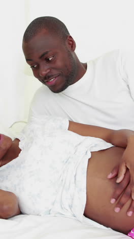 Pregnant-woman-lying-on-the-bed-with-her-husband