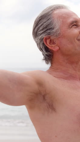 Retired-man-outstretching-arms-on-the-beach